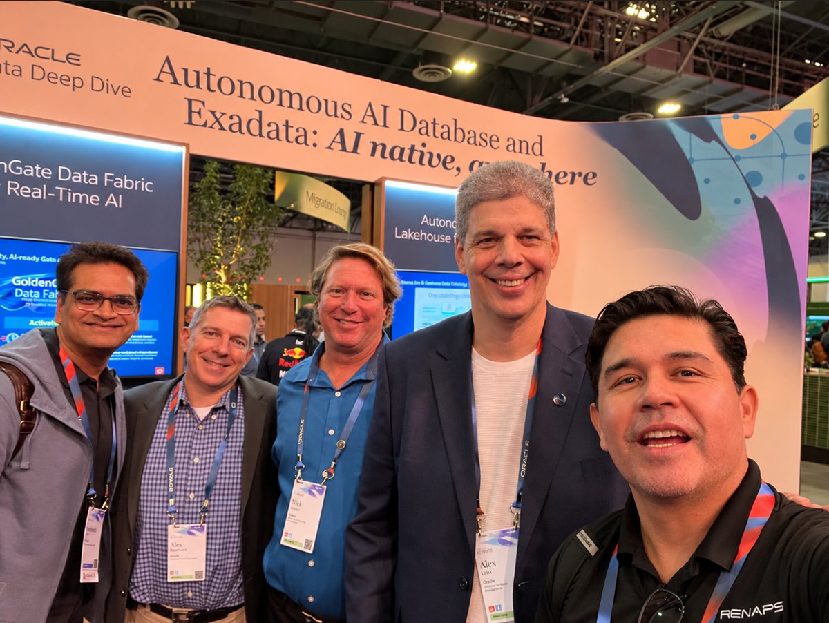 Five people smiling in front of the Oracle Autonomous AI Database and Exadata display at Oracle AI World 2026