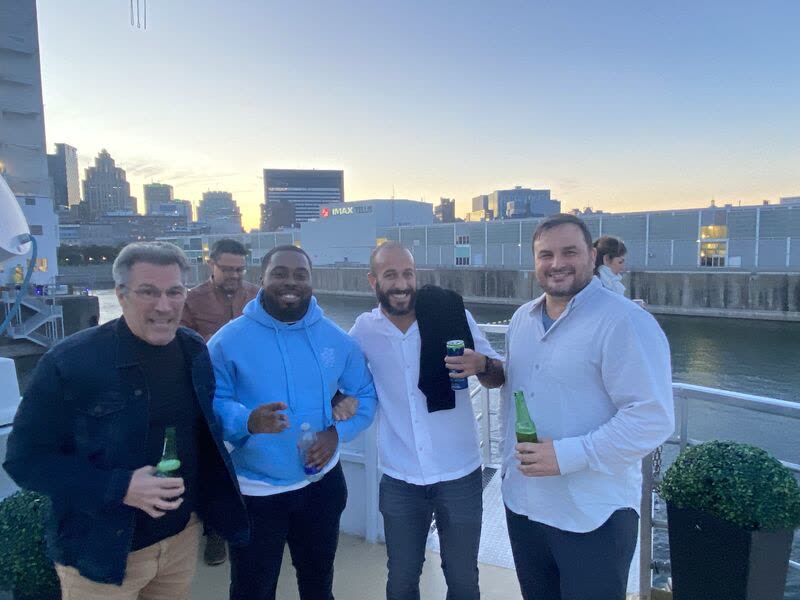 Team members chatting on the deck at sunset